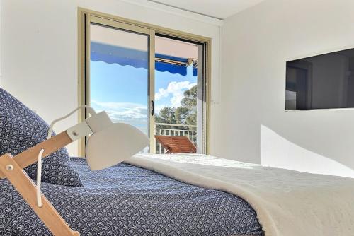 une chambre avec un lit et une grande fenêtre dans l'établissement Le Diamant vue grandiose sur port et mer, piscine privée, à Saint-Raphaël