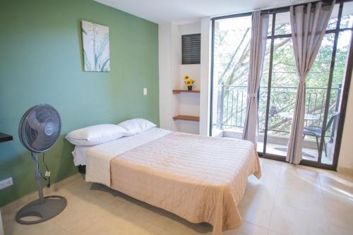 a bedroom with a bed and a fan in it at Edificio Fenicia Lofts Laureles in Medellín