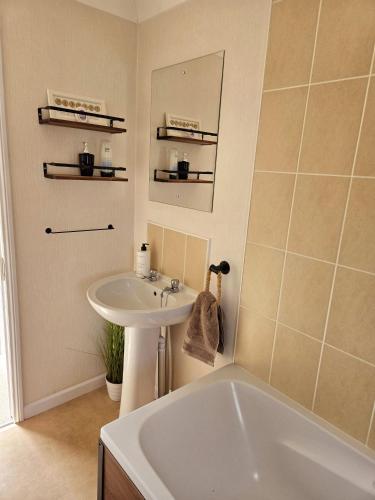 a bathroom with a white tub and a sink at Dottys lodge in Felton