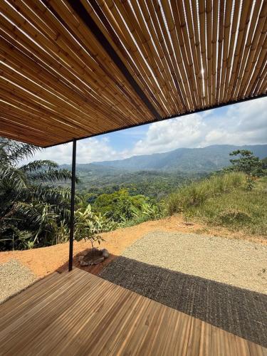 a wooden deck with a view of the mountains at Casa Morpho, Modern Studio with Unique Waterfall Views in Barú