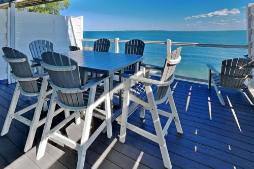 a blue table and chairs on a deck with the ocean at Put-in-Bay Waterfront Condo #207 in Put-in-Bay