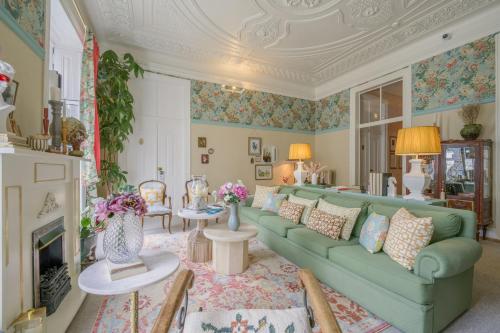 a living room with a green couch and a fireplace at Casinha das Flores in Lisbon
