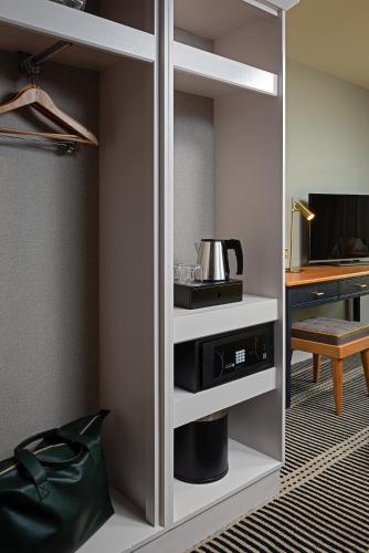 a room with a kitchen with a coffee maker in a cabinet at The Parkavon Hotel in Killarney