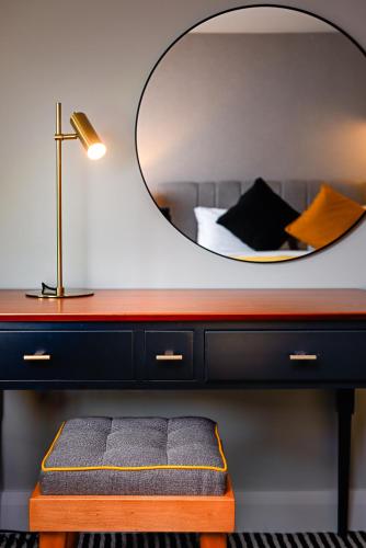 a bedroom with a bed and a mirror on a desk at The Parkavon Hotel in Killarney