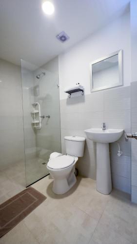 a bathroom with a toilet and a sink at Edificio Fenicia Lofts Laureles in Medellín