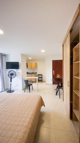 a bedroom with a large bed and a kitchen at Edificio Fenicia Lofts Laureles in Medellín