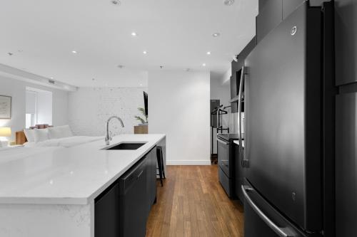 a kitchen with a sink and a black refrigerator at The SFX Old Port in Montréal