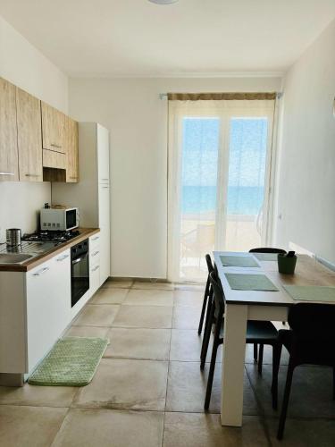 a kitchen with a table and a dining room at Cori di Capreria in Marina di Palma