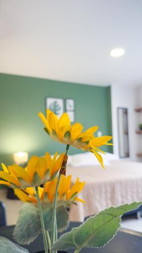 a vase filled with yellow flowers on a table at Edificio Fenicia Lofts Laureles in Medellín