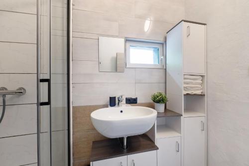 Un baño con lavabo blanco y ducha. en Zum Stumpfen Turm, en Morbach