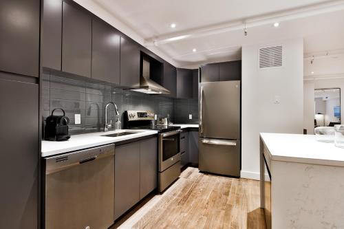 a kitchen with stainless steel appliances and wooden floors at The SFX Old Port in Montréal