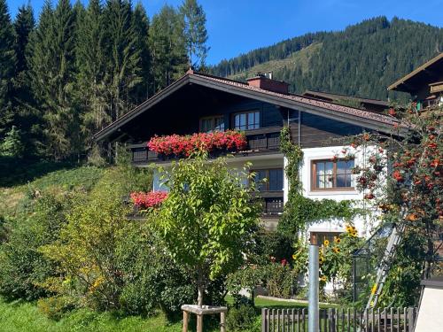 Una casa con flores al costado. en Haus Andrea Unterberger, en Flachau