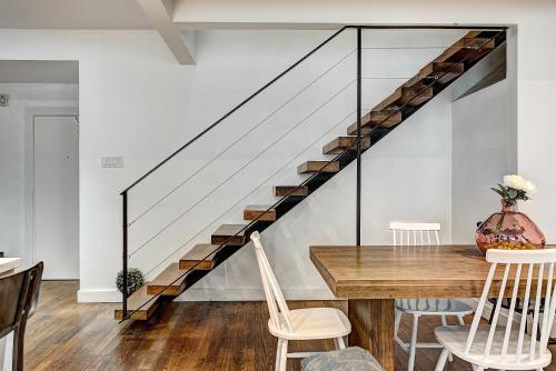 a dining room with a table and a staircase at The SFX Old Port in Montréal