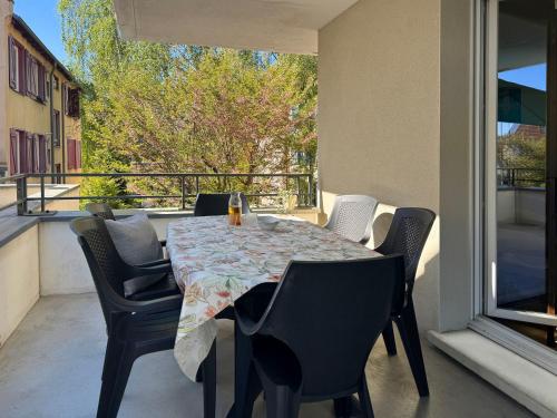 d'une table et de chaises sur un balcon avec une table et une fenêtre. dans l'établissement Joli 3P avec terrasse et Garage proche Centre, à Strasbourg