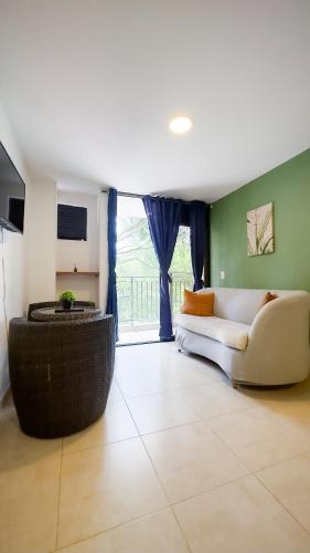a living room with a white couch and a window at Edificio Fenicia Lofts Laureles in Medellín