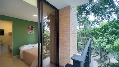 a bedroom with a sliding glass door to a balcony at Edificio Fenicia Lofts Laureles in Medellín