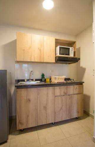 a kitchen with a sink and a microwave at Edificio Fenicia Lofts Laureles in Medellín