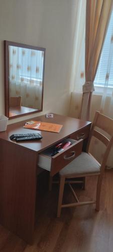 a desk with a computer and a chair with a mirror at Stephanovy Guest House in Sozopol