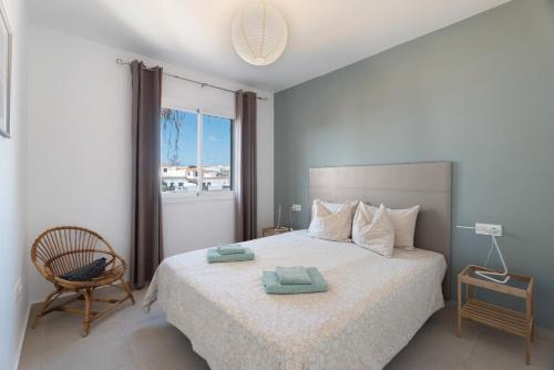 een slaapkamer met een bed met een stoel en een raam bij casa agua y sol 2 in Poris de Abona