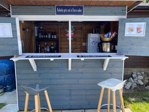 a drink booth with two stools in front of it at The Belmont in Shanklin