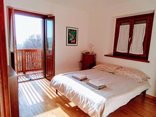a bedroom with a bed and a balcony at Casa della Meridiana in Clastra