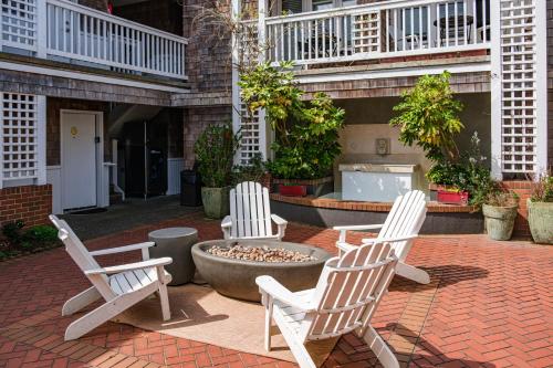 three white chairs sitting around a fountain in a courtyard at Cannon Beach Hotel Collection in Cannon Beach