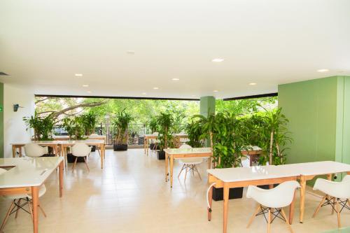 a restaurant with tables and chairs and plants at Edificio Fenicia Lofts Laureles in Medellín
