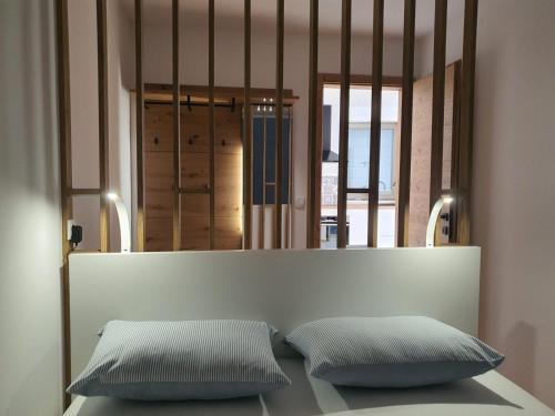 two pillows sitting on a bed in front of a mirror at Concha Aurea Apartments in Sveti Juraj