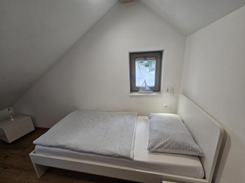 a white bed in a room with a window at Concha Aurea Apartments in Sveti Juraj