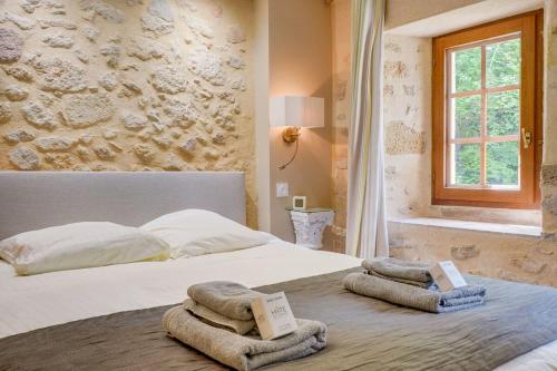 une chambre avec un lit avec des serviettes dessus dans l'établissement Charming home with a pool, à Blasimon