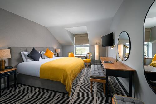a hotel room with a bed and a desk and a mirror at The Parkavon Hotel in Killarney