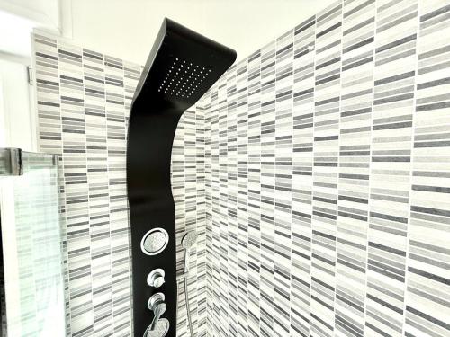 a shower with a black and white tiled wall at Casa Miró in Arona
