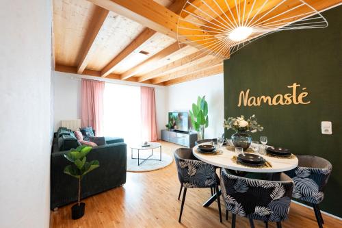 a living room with a table and some chairs at NAMASTÉ Homes - Ferienwohnung mit Balkon & Carport in Bad Windsheim