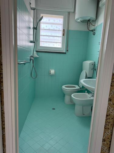 a blue bathroom with two toilets and a window at Appartamento Gina lido di savio in Lido di Savio