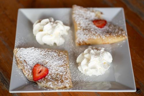 a plate with four deserts with strawberries and powdered sugar at House Boat s výhledem na Wake Port in Brandýs nad Labem-Stará Boleslav