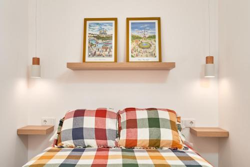 un letto con due immagini sul muro e due cuscini di Aparartamento Abril a Castillo Bajo