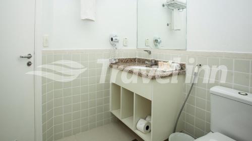 a bathroom with a sink and a shower at Travel Inn Flats Riviera in Riviera de São Lourenço