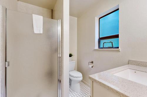 a bathroom with a toilet and a sink and a window at Tree House in Sea Ranch
