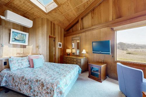 a bedroom with a bed and a flat screen tv at Curtis-Moulton Retreat in Sea Ranch