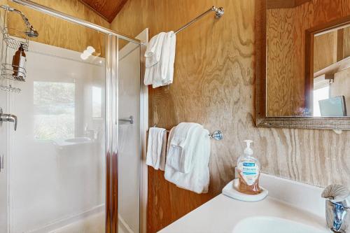 a bathroom with a shower and a sink and a mirror at Curtis-Moulton Retreat in Sea Ranch