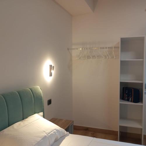a bedroom with a bed with a green headboard at La finestra sugli ulivi in Pezze di Greco
