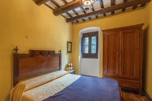 a bedroom with a large bed with a wooden headboard at Can Marc in Dosríus