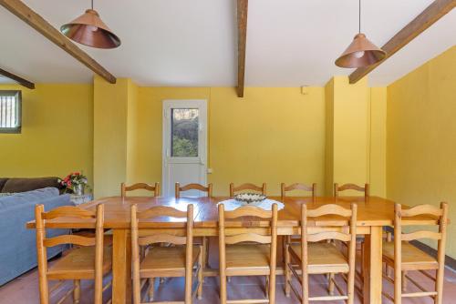 a dining room with a wooden table and chairs at Can Marc in Dosríus