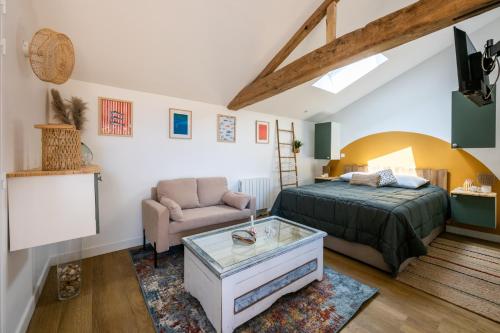 ein Schlafzimmer mit einem Bett, einer Couch und einem Tisch in der Unterkunft Bontempo Village La Yole in Saint-Jean-de-Monts
