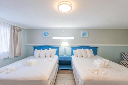 two beds sitting next to each other in a room at The Janmere Motel in Hampton