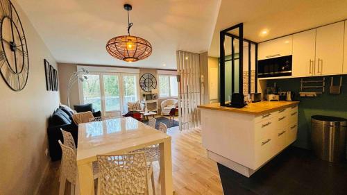 une cuisine et un salon avec une table et une salle à manger dans l'établissement Appart T3 pinède 5 min de la plage, à Le Touquet-Paris-Plage