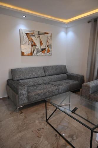 a living room with a couch and a glass table at Résidence Le Marin in Banī ‘Aţāʼ