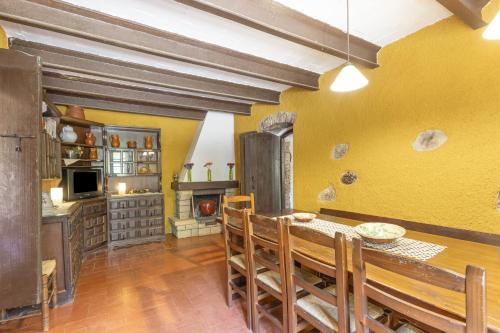 a dining room with a table and a kitchen at Can Marc in Dosríus