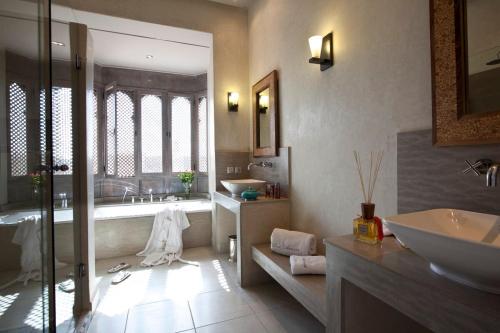 a bathroom with a tub and a sink at Villa de luxe avec piscine sur le golf d'amelkis in Marrakech