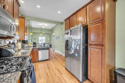 a kitchen with wooden cabinets and a stainless steel refrigerator at Stylish 2-Story Home - Perfect Denver Location home in Denver